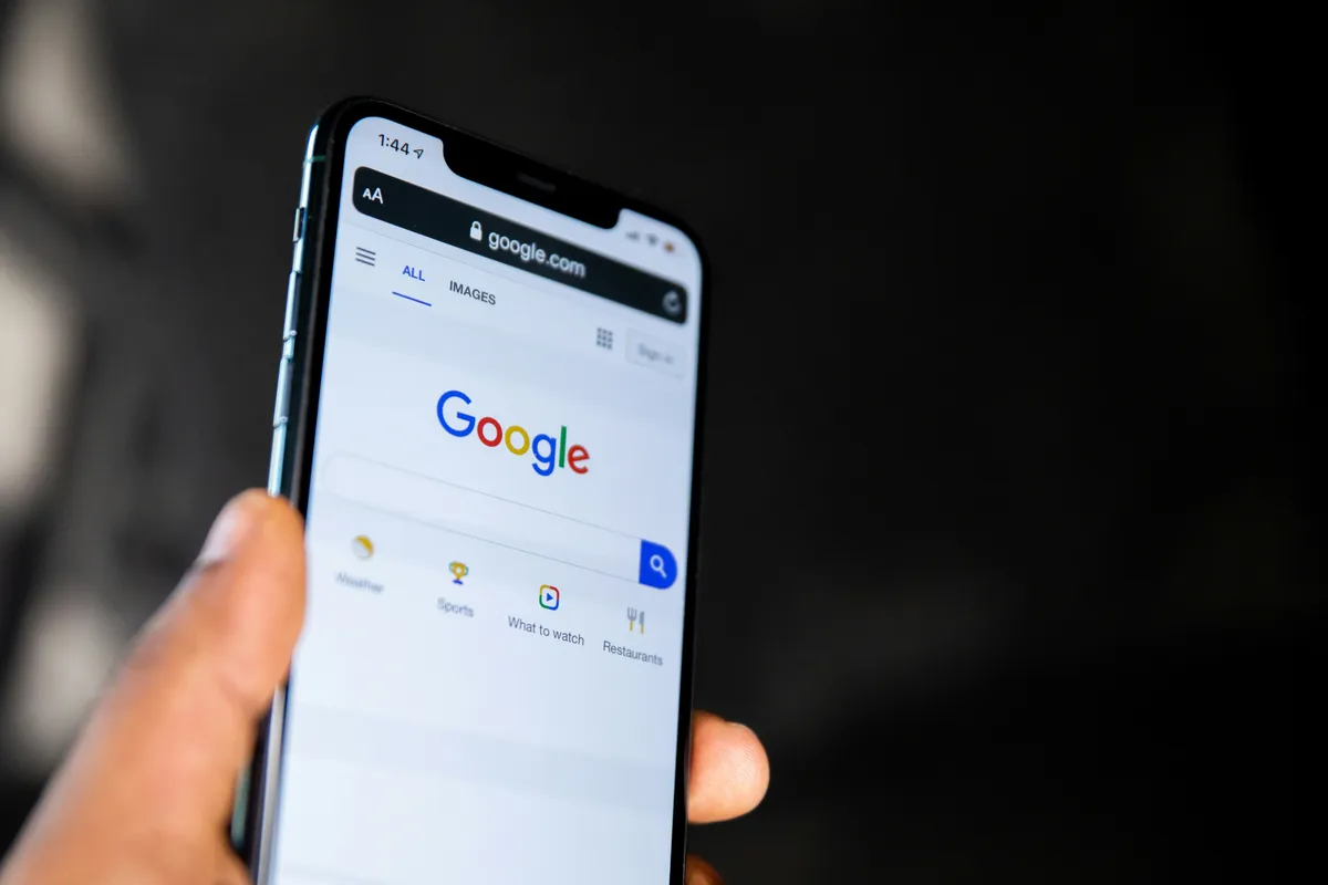Hånd der holder en forstørrelsesglas op mod en Google-søgeside